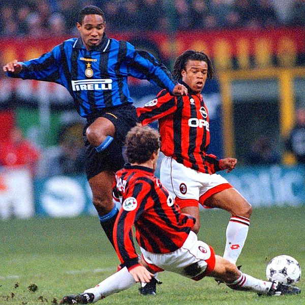 Milano, stadio Giuseppe Meazza, 24 novembre 1996. Il nerazzurro Paul Ince (in alto) contrastato dai rossoneri Edgar Davids (al centro) e Franco Baresi (in basso), nel derby di Milano tra Inter e Milan (1-1) valevole per la 10ª giornata del campionato italiano di Serie A 1996-1997.